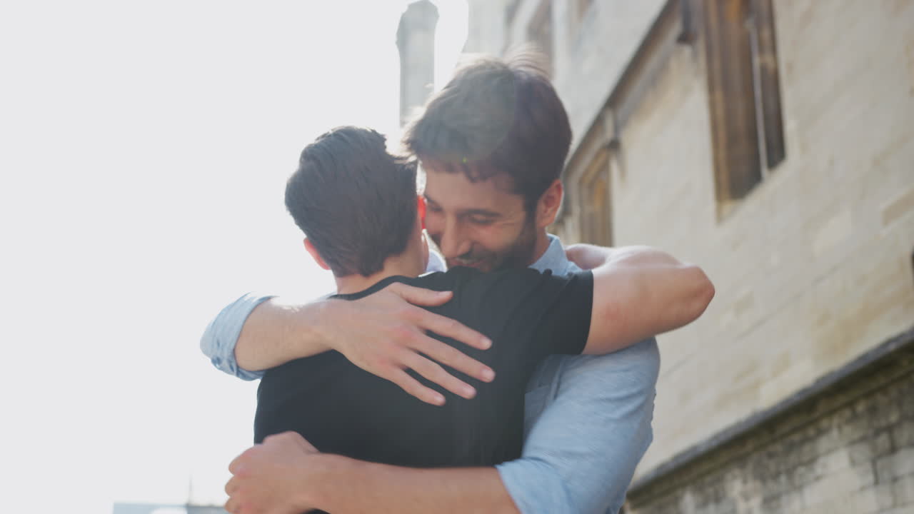 Coppia gay maschile affettuosa che si abbraccia all'aperto in una strada della città