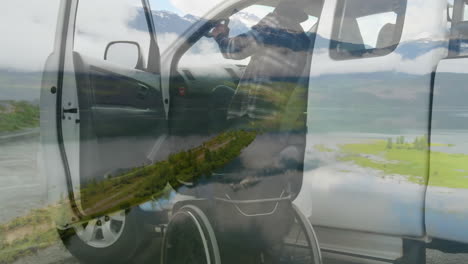 transferring into vehicle, person in wheelchair over scenic mountain landscape