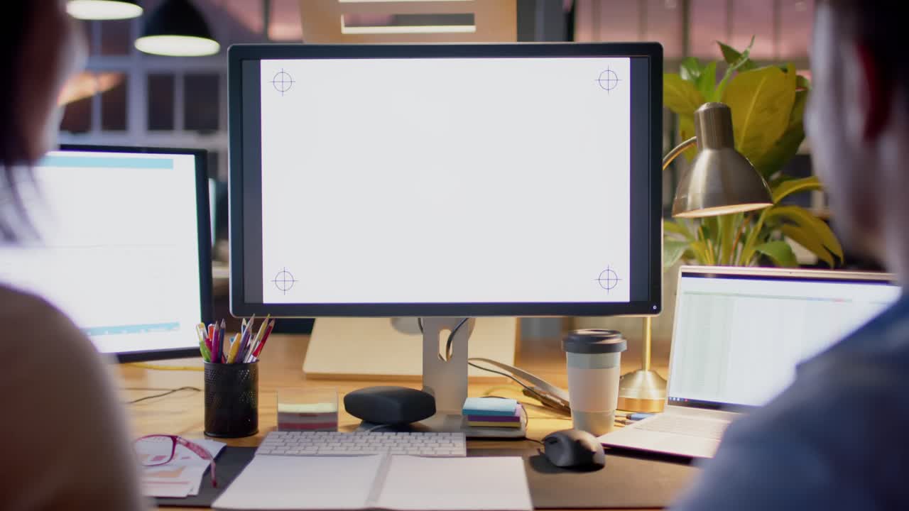 다양한 남녀 동료가 사무실에서 밤에 복사 공간을 가진 컴퓨터를 사용하고 대화합니다.