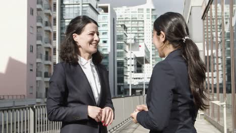 coworkers shaking hands and talking on street