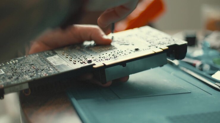 Tattooed technician repairing computer graphics card