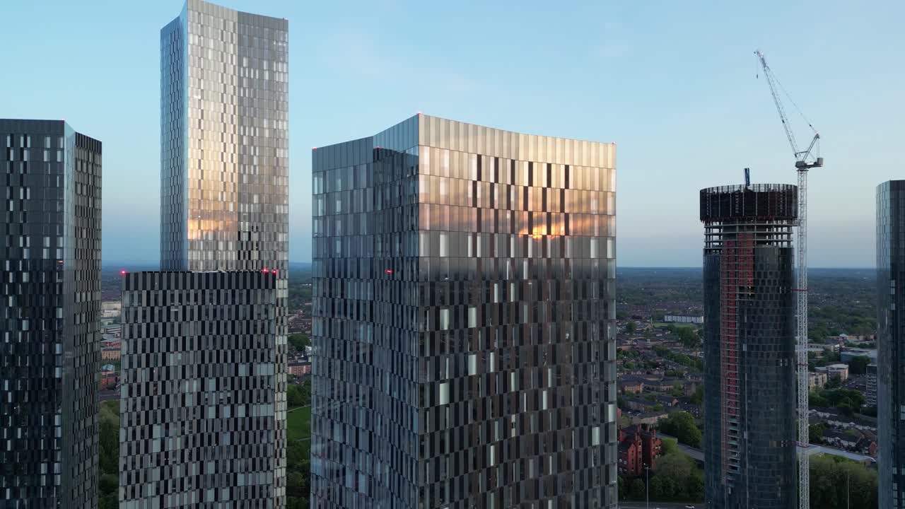 полет беспилотного самолета, пролетающего мимо deansgate square towers в начале вечера при заходе солнца в центре манчестера