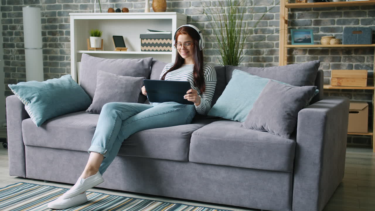 mujer relajándose en el sofá con la tableta