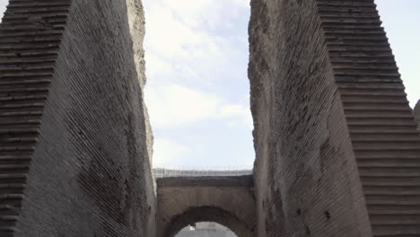 pan of colosseum walls and arches in rome, italy
