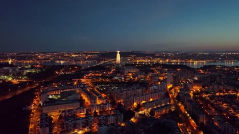 aerial footage flying forward over almada, facing christo rei and lisbon, right before sunrise