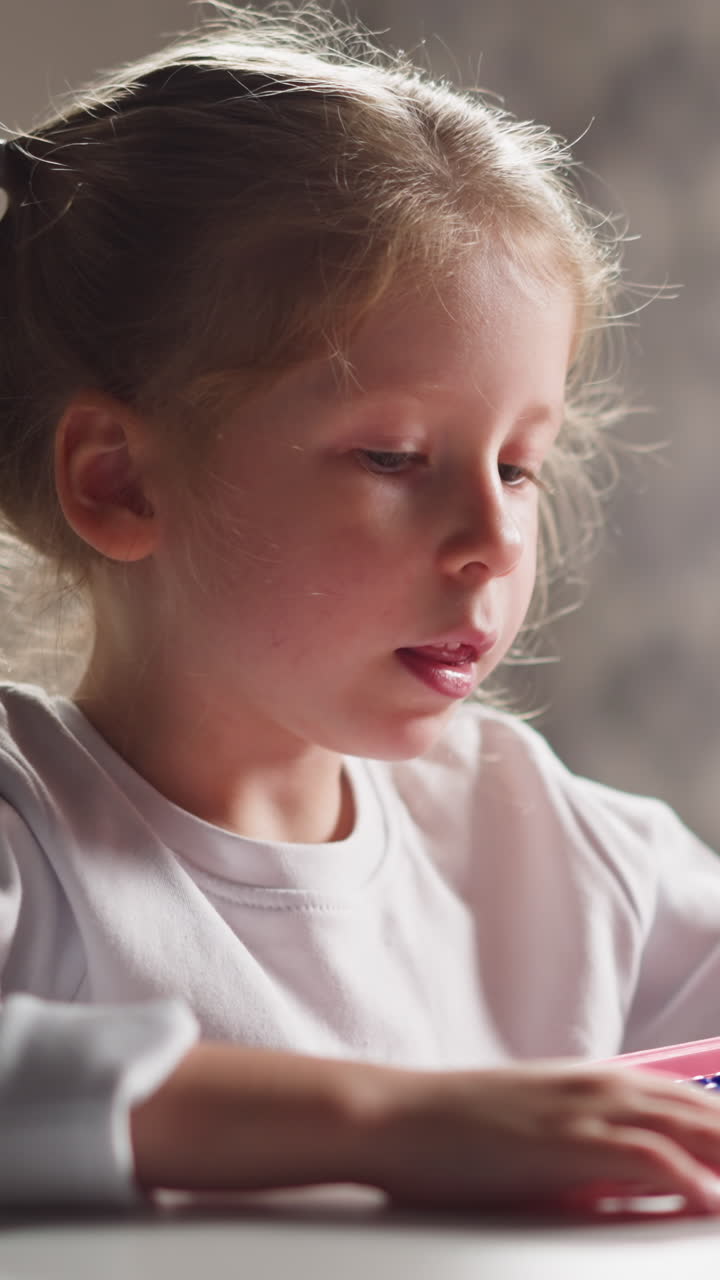 Pretty little girl preschooler learns to count by colorful toy abacus and talks at mental arithmetics lesson at home closeup slow motion