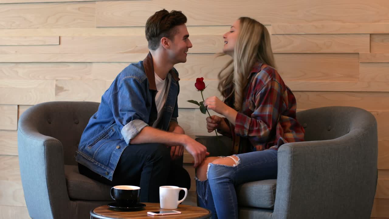 una joven pareja romántica interactuando entre sí en un café 4k