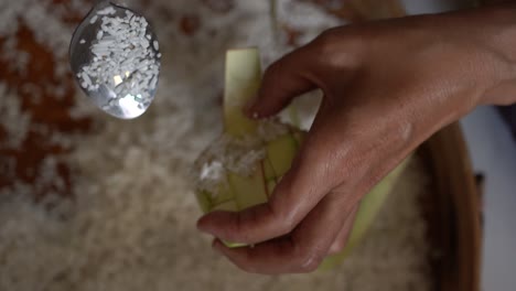 the process of putting rice in the ketupat, before cooking