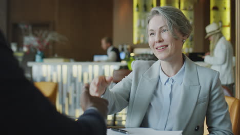 woman signing business contract on meeting in restaurant
