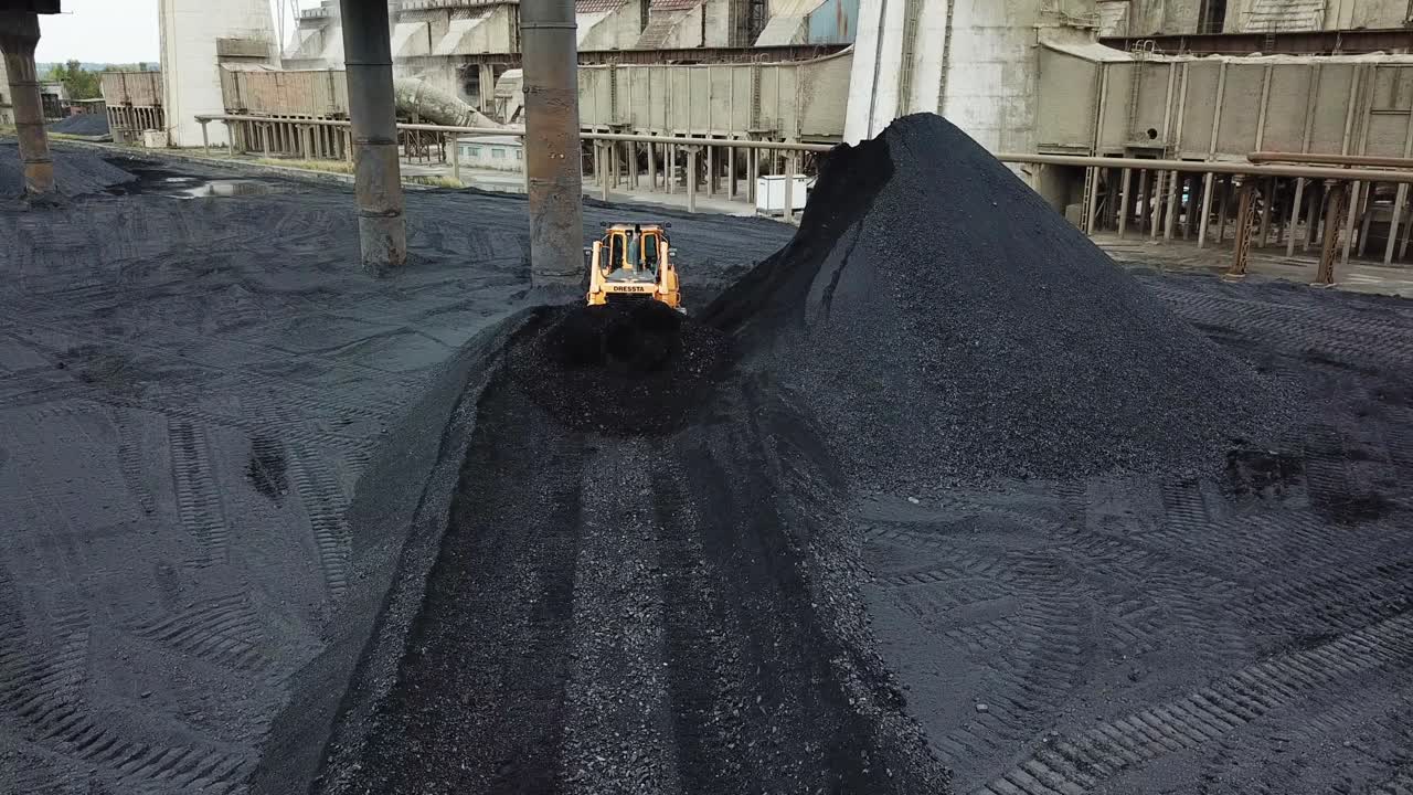 Bulldozer moving coal. Tractor on production of coal in a traditional manner