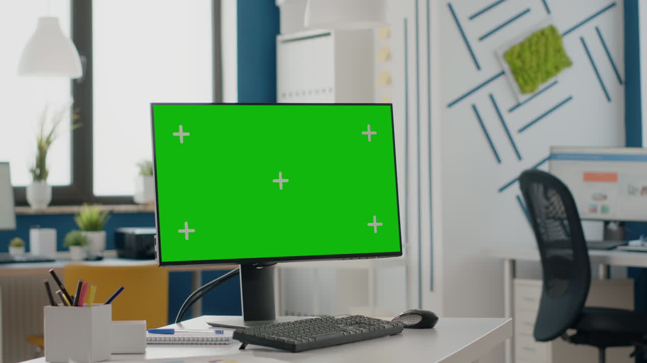Close up of empty desk with isolated green screen on monitor