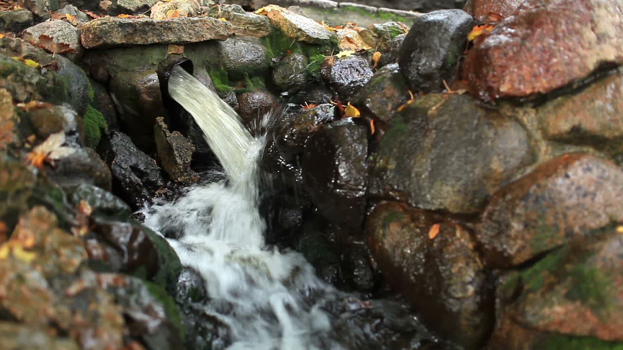 Water pours from a pipe in the city park
