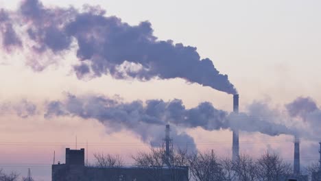 industrial smoke stacks at sunrise/sunset