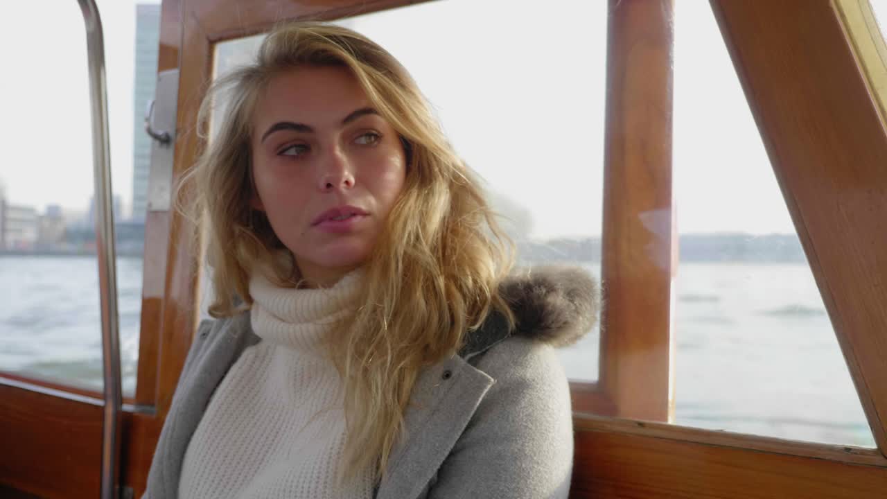 강을 건너는 페리에 앉아 자신감 있는 젊은 여성