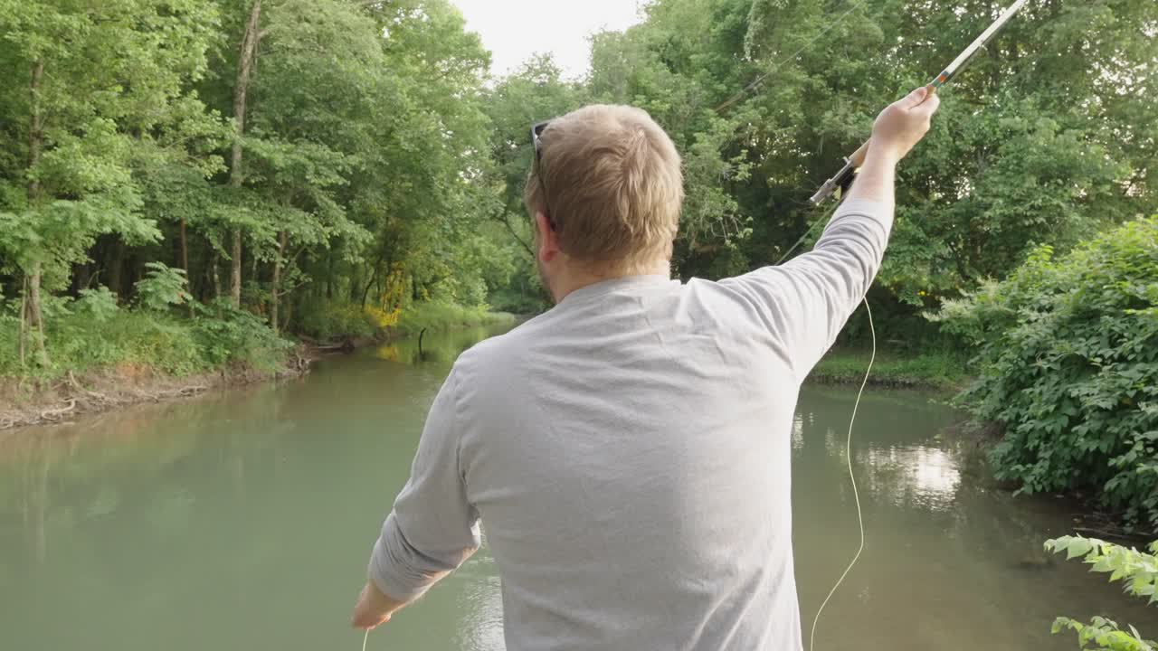 Video gerak lambat seorang pria memancing dengan teknik fly fishing di Sungai Eleven Point di Thomasville, Missouri