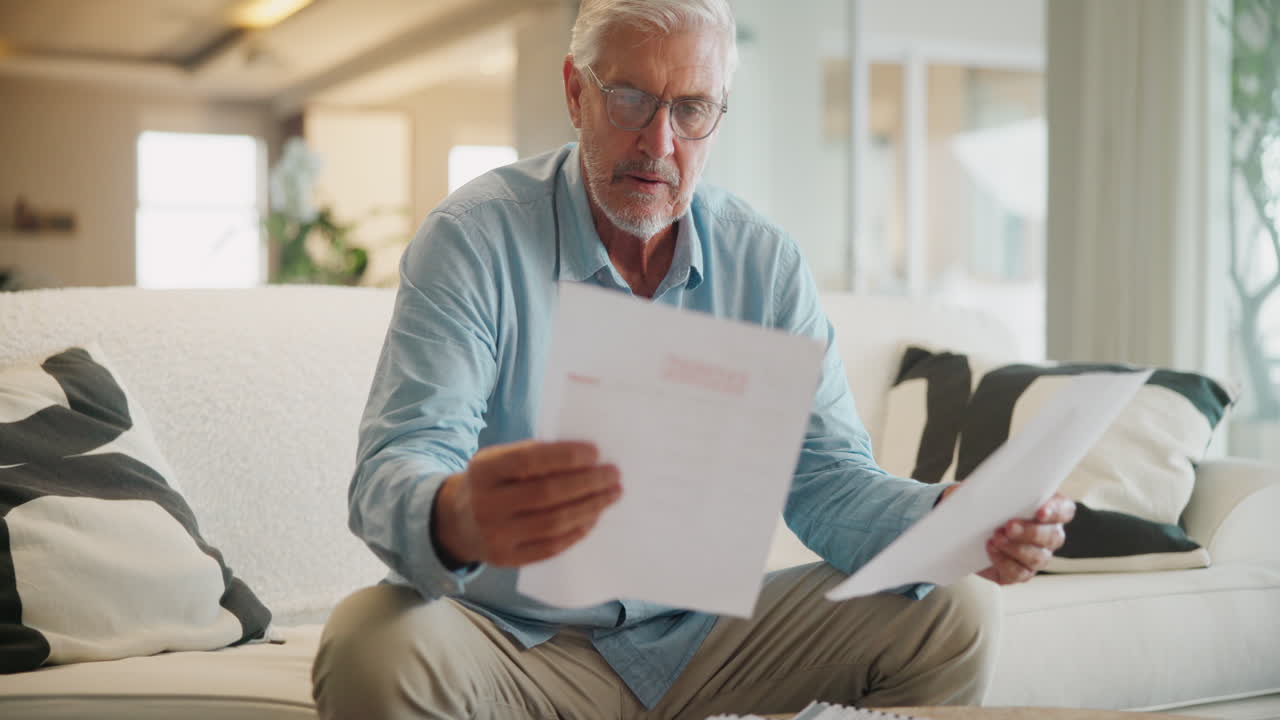 Senior man reviewing documents at home