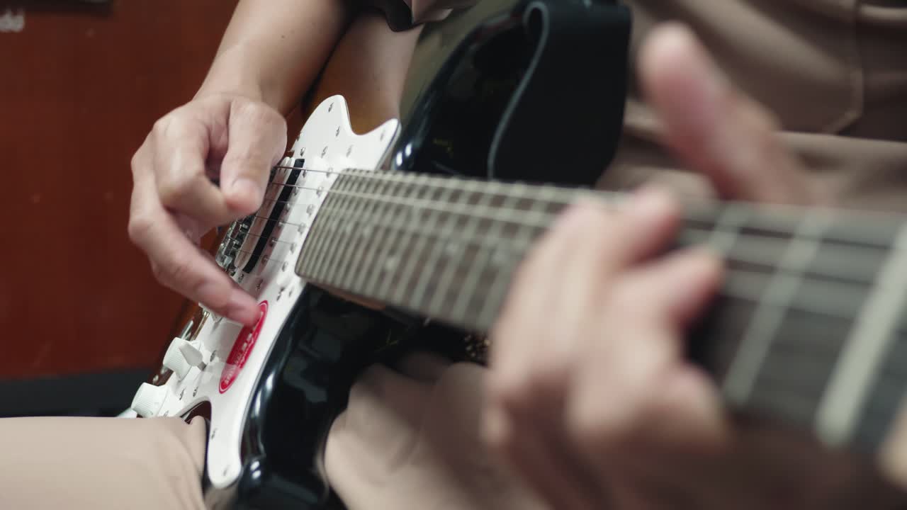 el primer plano de un hombre practicando tocar la guitarra tiene una hermosa escena.