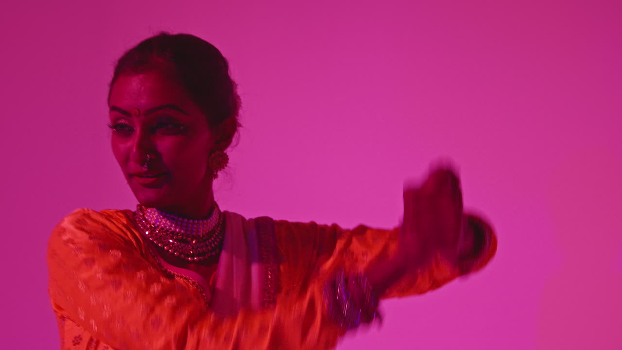 Head And Shoulders Studio Shot Of Female Kathak Dancer Performing Dance Wearing Traditional Indian Dress Against Purple Background 1