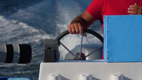 Focus-shot,-Hand-holds-on-a-Boat-Steering-wheel-on-the-river-of-Adolfo-Lopez-Mateos-Baja-California-sur,-Mexico