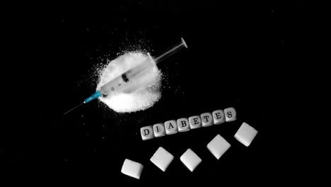 syringe falling into pile of sugar besides white dice spelling out diabetes and sugar cubes