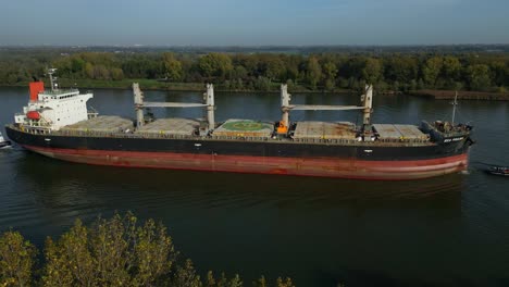 Toma-Aérea-Del-Buque-Granelero-Mar-Prajna-Navegando-En-El-Canal-De-Panamá-Bordeado-De-árboles