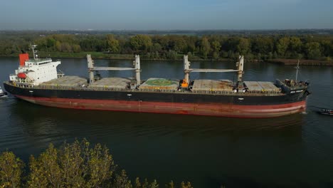 toma aérea del buque granelero mar prajna navegando en el canal de panamá bordeado de árboles