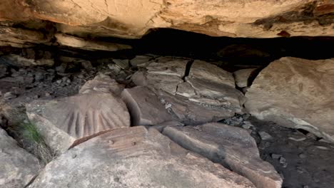 rocks falling and dust rising at a cave mouth