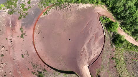 vista aérea de arriba hacia abajo de una pareja abrazándose en una zona volcánica de forma circular