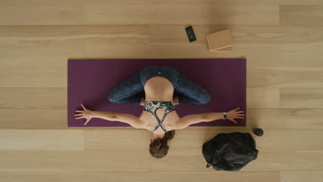 overhead view flexible yoga woman practicing stretching body enjoying healthy lifestyle exercising in fitness studio training on exercise mat