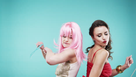 girlfriends dancing wearing red dress and pink hair in slow motion party photo booth