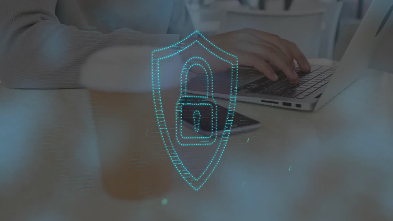 animación de un candado en el escudo sobre la sección media de un hombre biracial bebiendo café y usando una computadora portátil