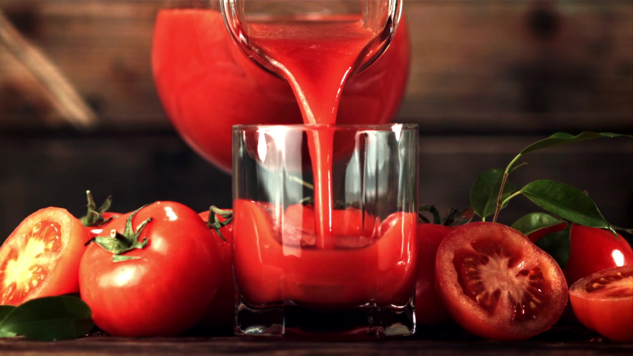Despejo em Câmera Lenta de Suco de Tomate Fresco em um Copo