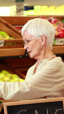pareja de ancianos recogiendo verduras en el supermercado