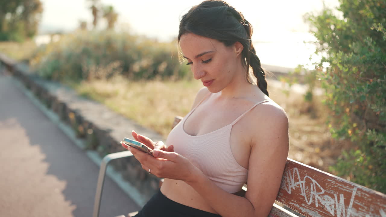 Uma mulher usando um celular em um banco
