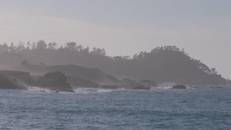 slow motion shot of the ocean with foggy mountains background located in california marina state beach monterey bay