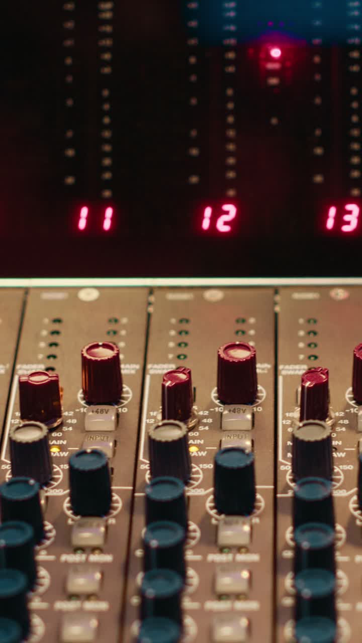 Close-up of Audio Mixing Console with Fluctuating Level Meters