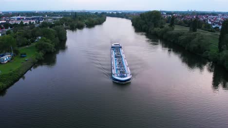 aerial view of a transport ferry on the main river, sunny evening, in raunheim, germany - reverse drone shot