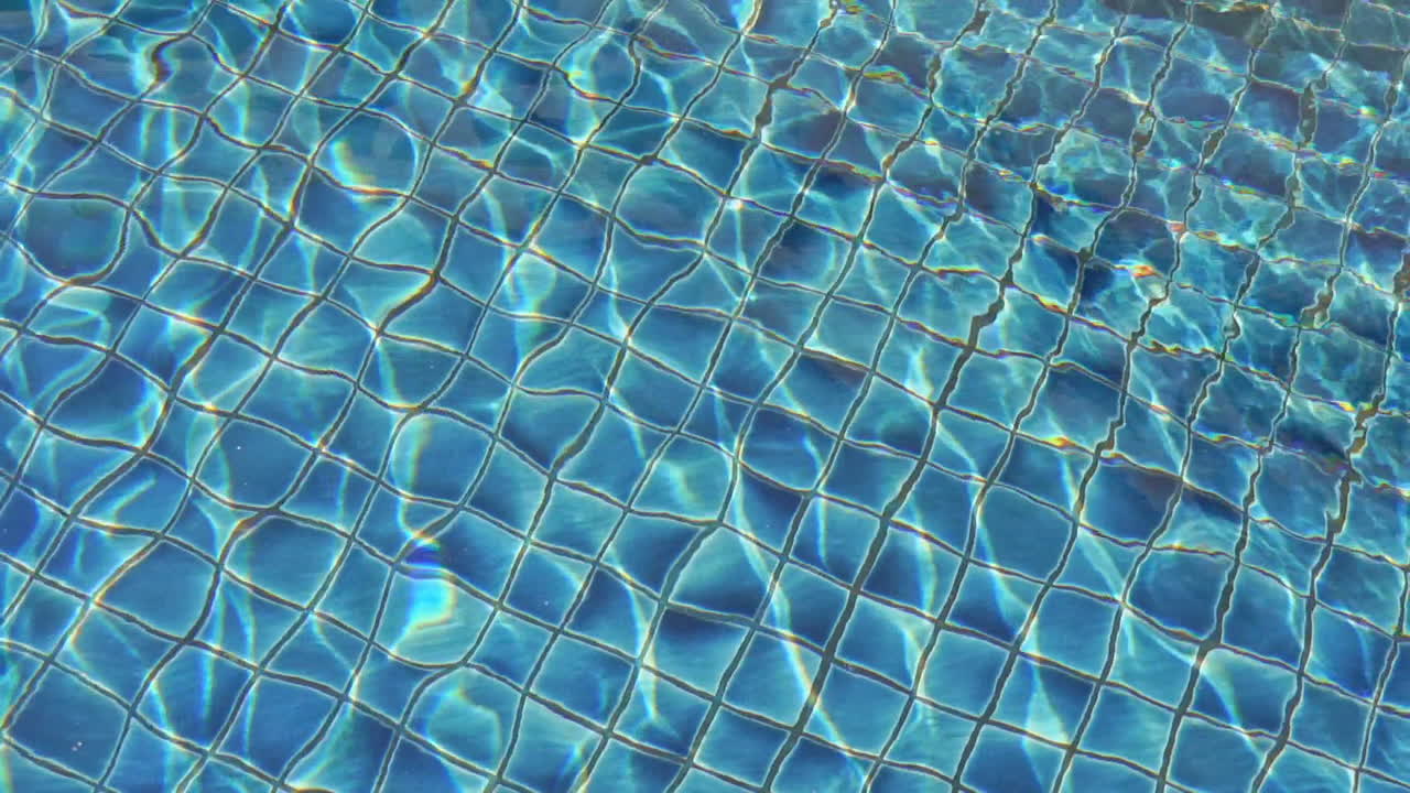 L'acqua si increspa e brilla sulle piastrelle sul fondo della piscina