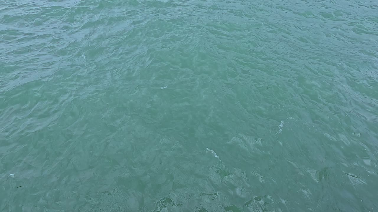 Gentle ocean waves captured at Koh Samui, Thailand. Calm turquoise water under natural daylight creates a serene atmosphere