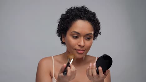 Concepto-De-Belleza,-Maquillaje-Y-Cosméticos-Sonriendo-Hermosa-Joven-Afroamericana-Aplicando-Rímel-Sobre-Fondo-Gris