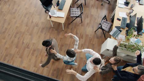 high angle view of joyful people office workers dancing in modern open space workplace