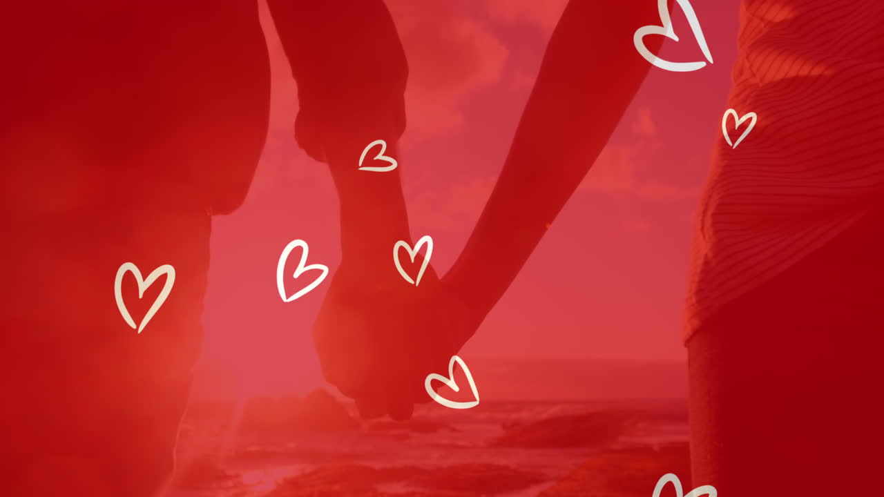 해변에서 손을 잡고 있는 백인 부부 위의 색 심장의 애니메이션