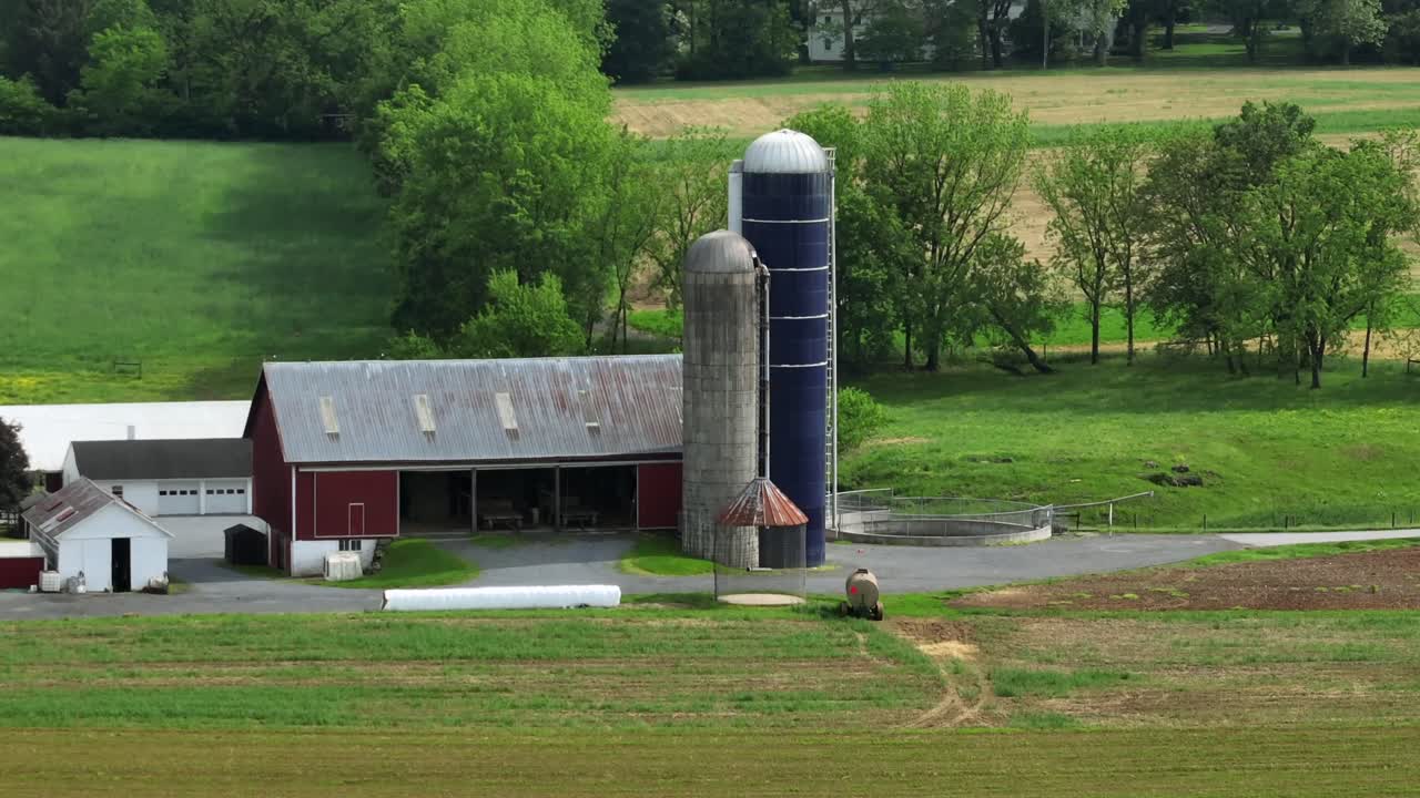 Mejeri og landejendom med lade og garage til maskiner på det amerikanske landskab. Solrig dag om foråret. Zoom-luftfoto. Siloanlæg i amerikansk forstad. Vidvinkelbillede