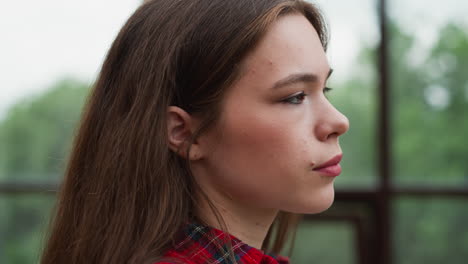 serious woman stands in studio closeup pretty lady suffers from obsessive thoughts looking out of