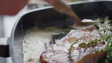 basting steak with butter while cooking in grill pan