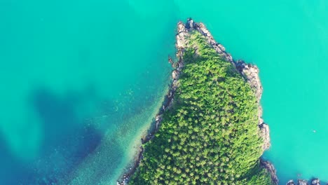 Hermoso-Cabo-De-Isla-Tropical-Verde-Con-Costa-Rocosa-Bañada-Por-Una-Laguna-Turquesa-Con-Arrecifes-De-Coral-Bajo-El-Agua,-Tailandia