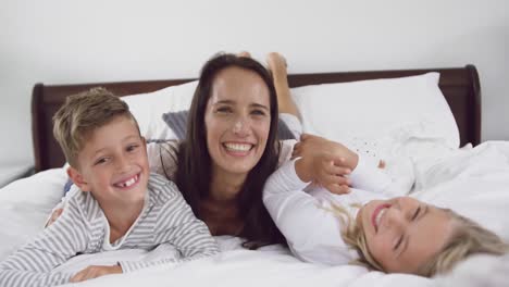 madre jugando con sus hijos en el dormitorio en casa 4k