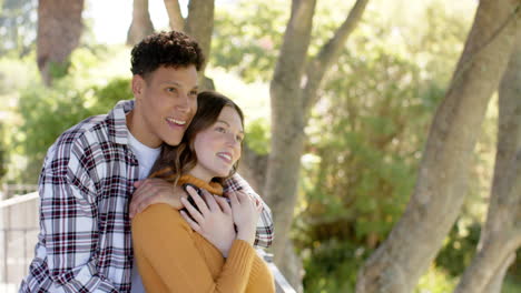 happy diverse couple standing on balcony and embracing at home, copy space, in slow motion