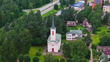 ikšķile lutheran church seen from above with active road in green summer forest