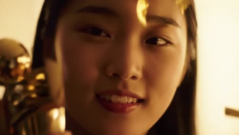 a close-up moment showcasing a young woman as she admires a golden trophy, capturing the emotions of joy and accomplishment in a beautifully lit setting